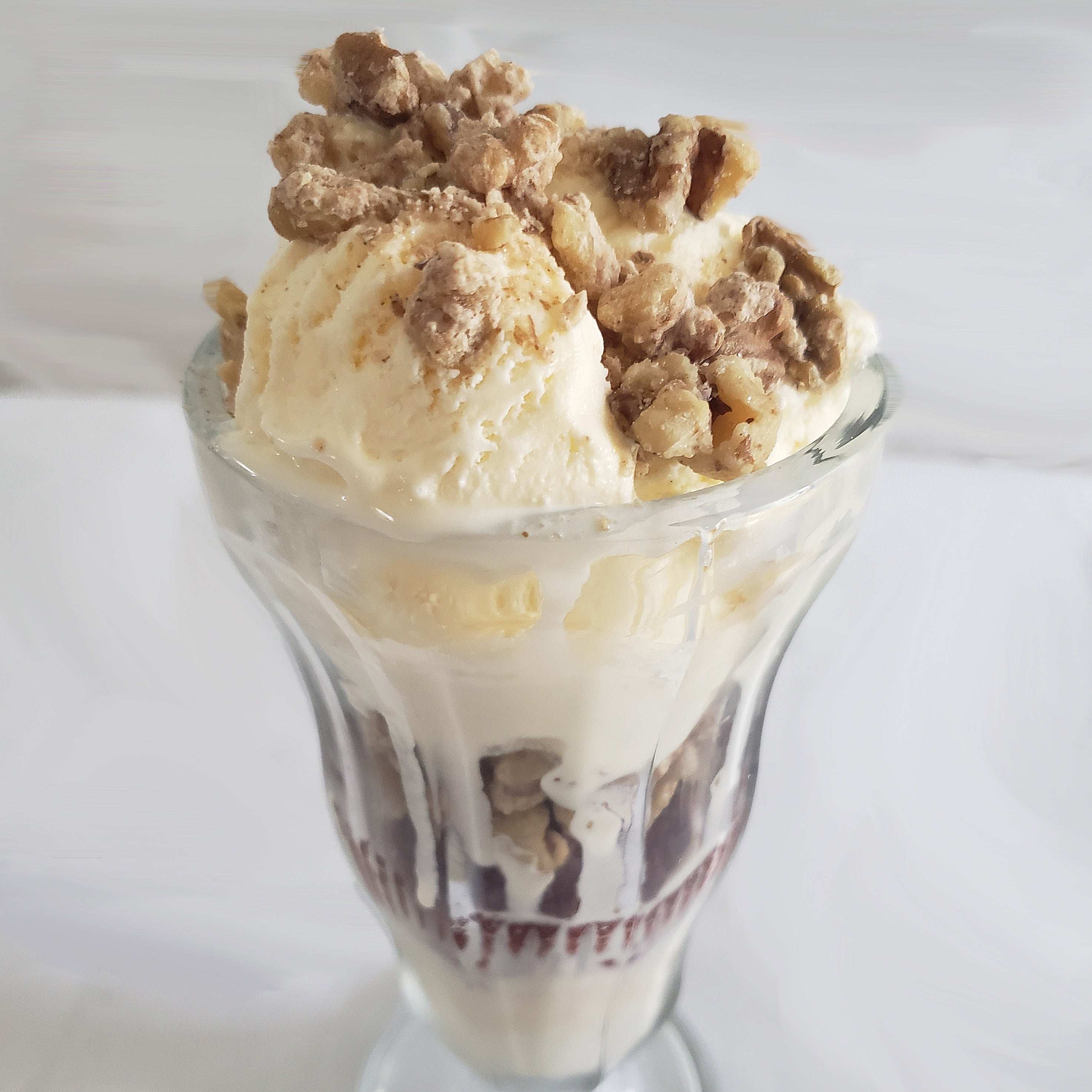 An ice cream sundae topped with oatmeal cookie coated walnut snacks