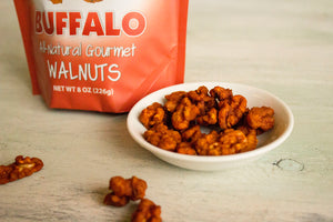 A bag and dish of buffalo seasoned walnut snacks  