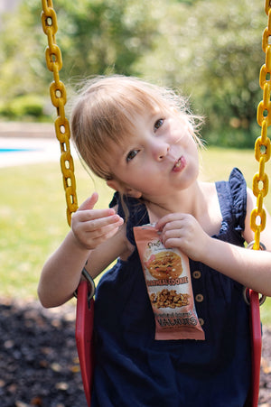 A little girl enjoying her oatmeal cookie walnut snacks in the true spirit of Crazy Go Nuts