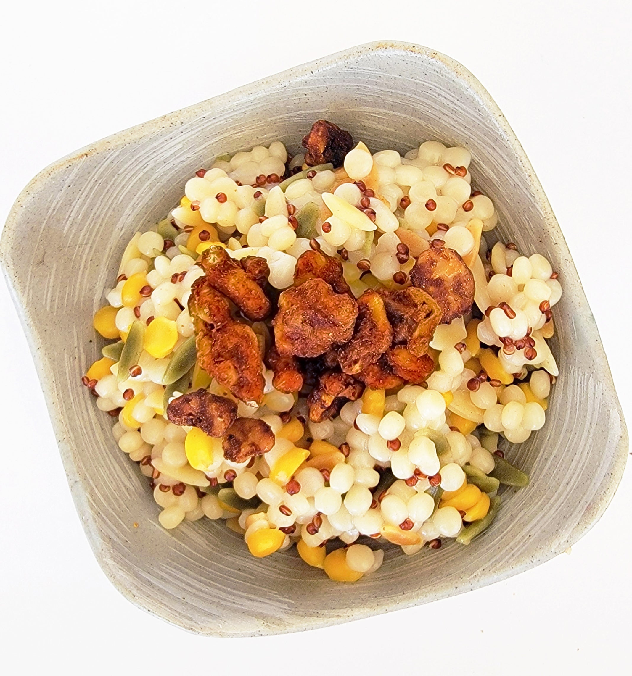 Sweet & spicy walnut snacks being used as a topping on a grain bowl