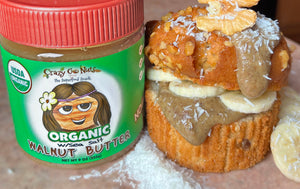 A jar of organic walnut butter next to a banana nut muffin dripping with walnut butter
