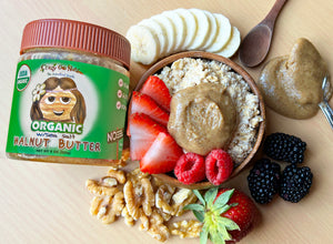  A jar of organic walnut butter with a bowl of oatmeal and fresh fruit